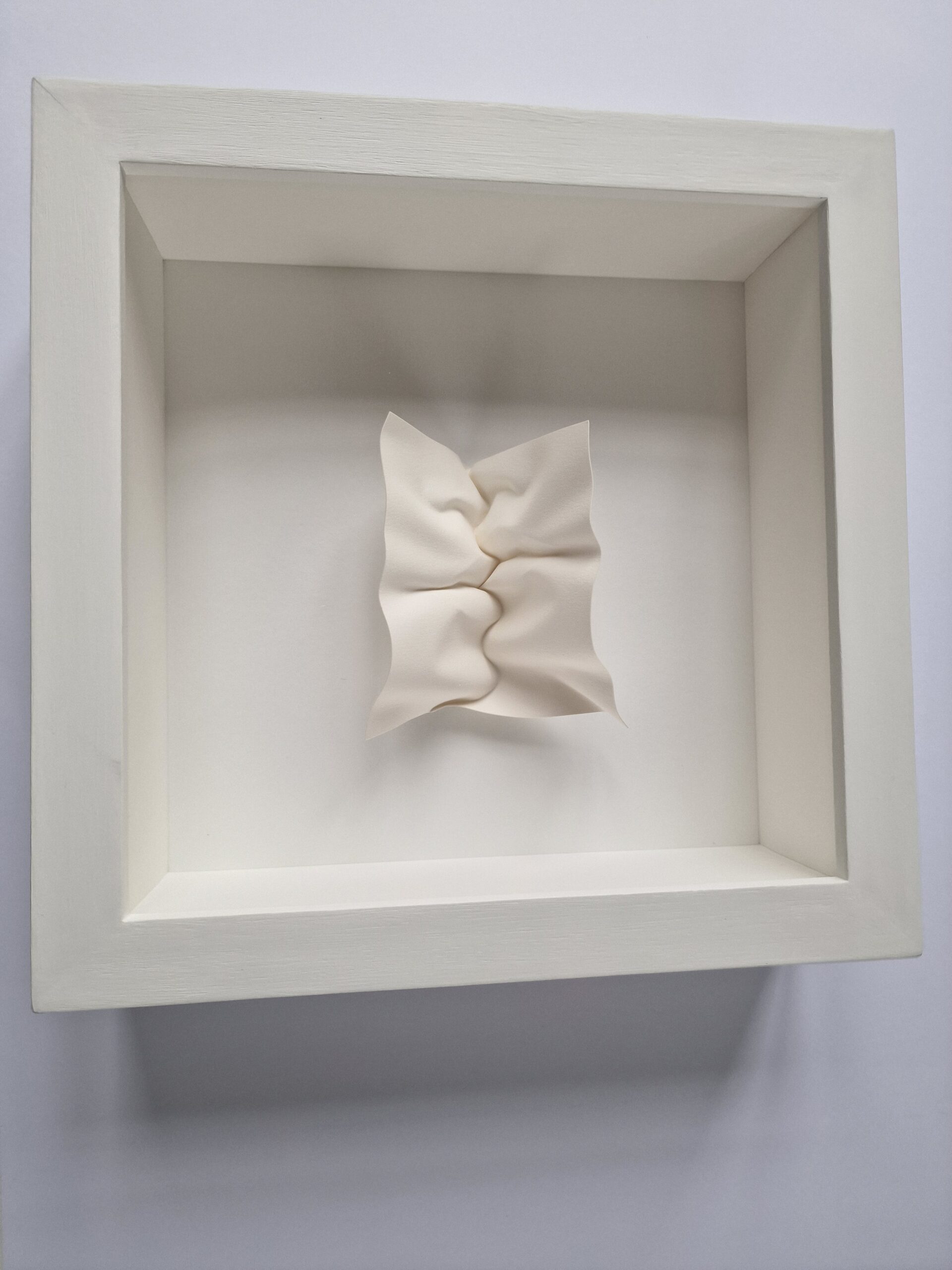 Paper sculpture handfolded into a kiss